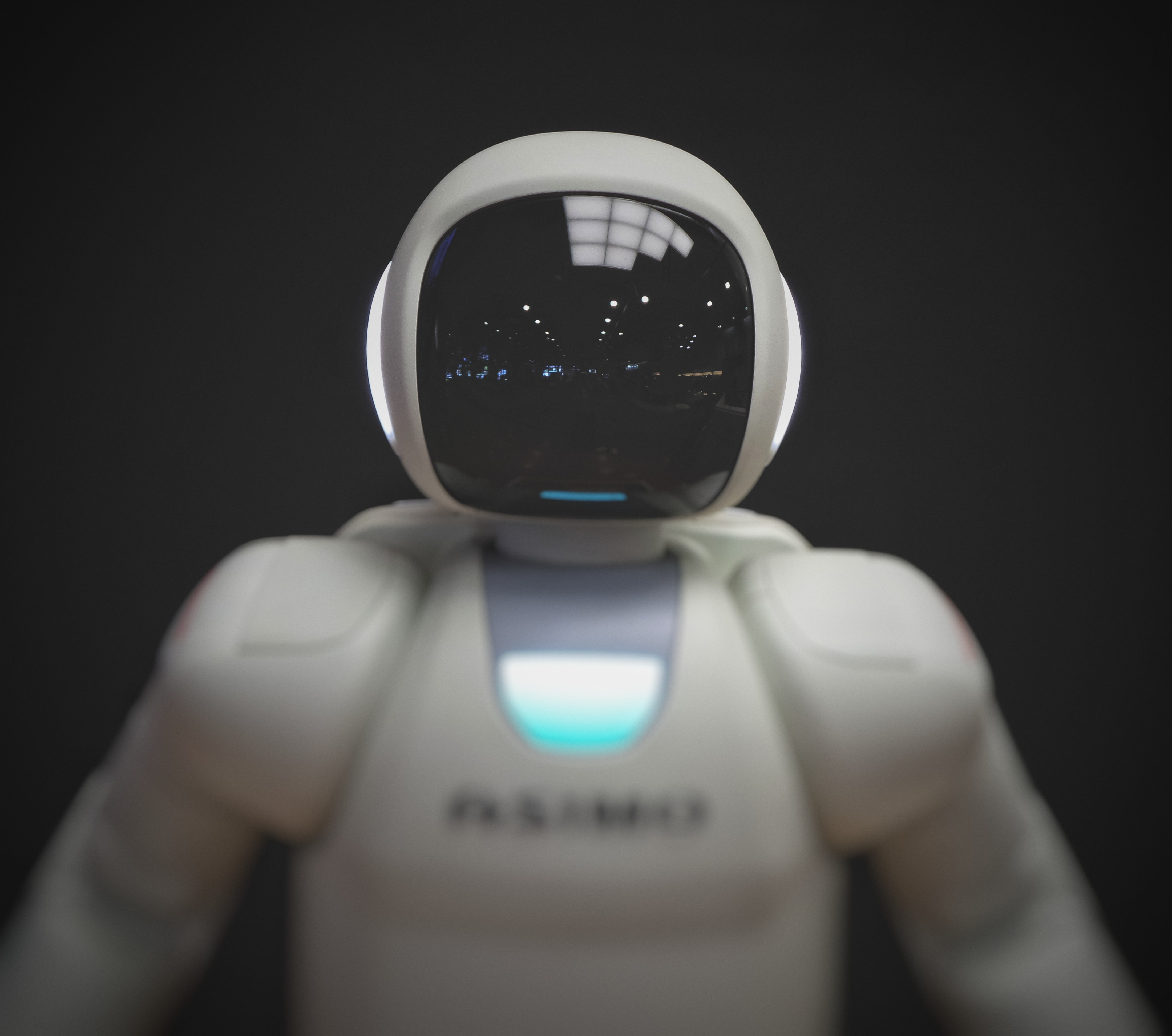 photo of a white plastic robot with
                a black background